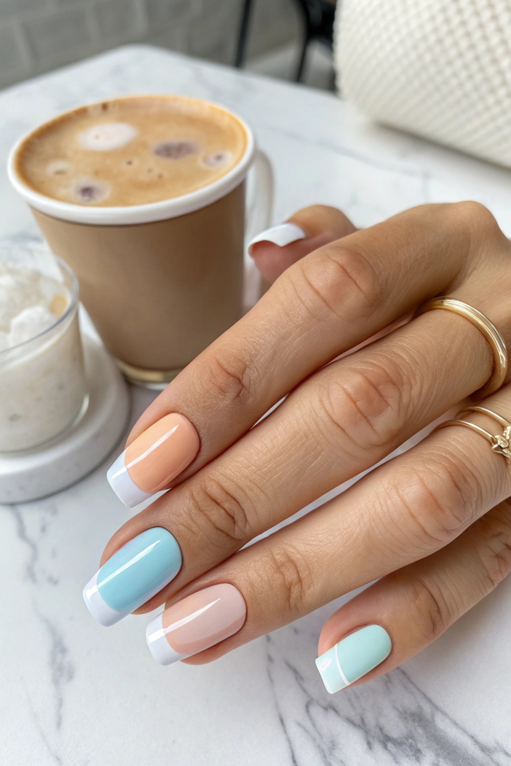 A modern take on the French manicure, with short nails featuring micro French tips in crisp white, soft pastels, or trendy summer hues like peach and sky blue.