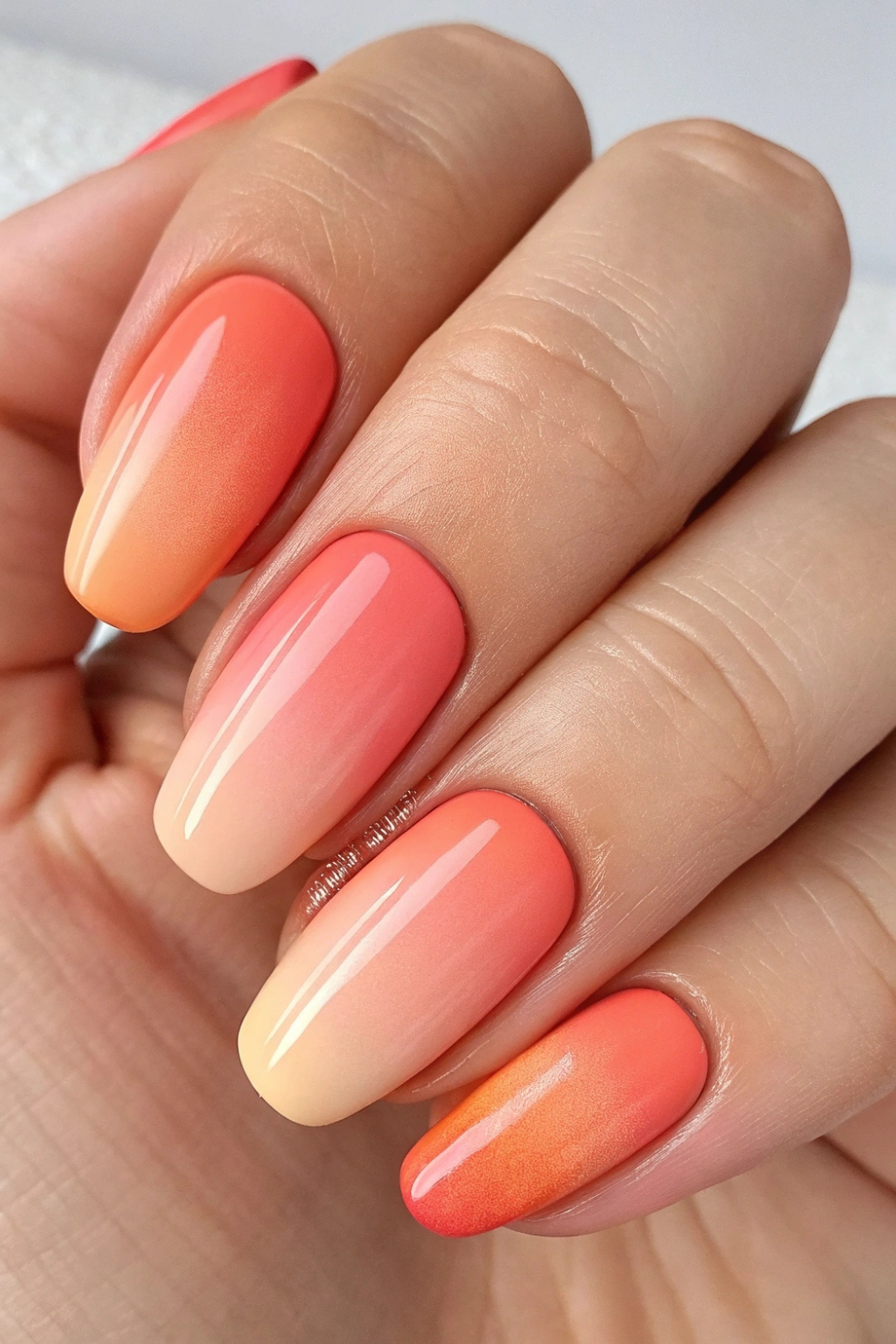 A mix of peach and soft coral creates a warm, fresh manicure that feels like sunshine on your hands.